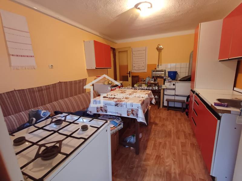 Konyha családi házban gáz tűzhellyel és fa dekoros padlóval.