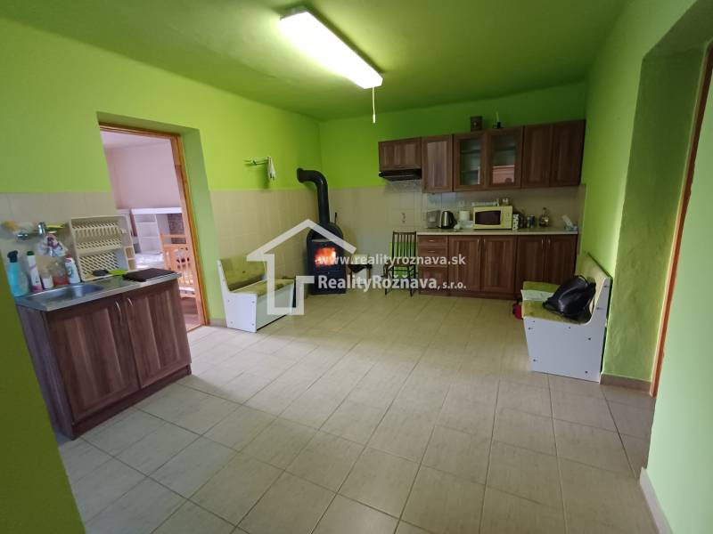 Konyha családi házban fa dekorációval, zöld falakkal, fatüzelésű kályhával.