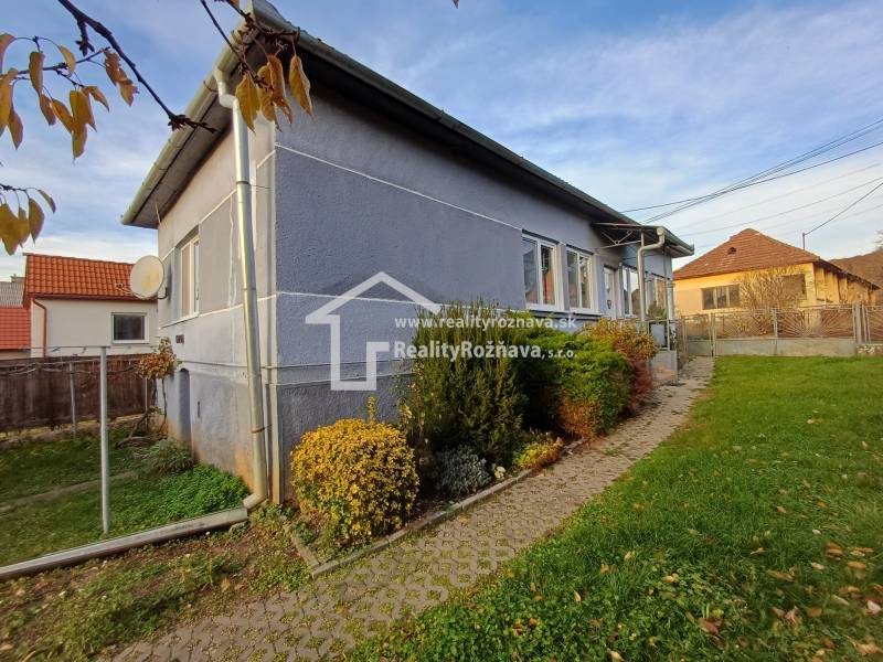Családi ház Dlhá Vesben, kert bokrokkal, burkolat a bejárathoz vezet.