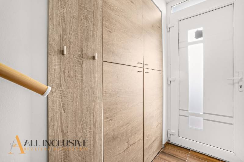 Előszoba beépített szekrénnyel és fehér ajtókkal egy háromszobás lakásban.