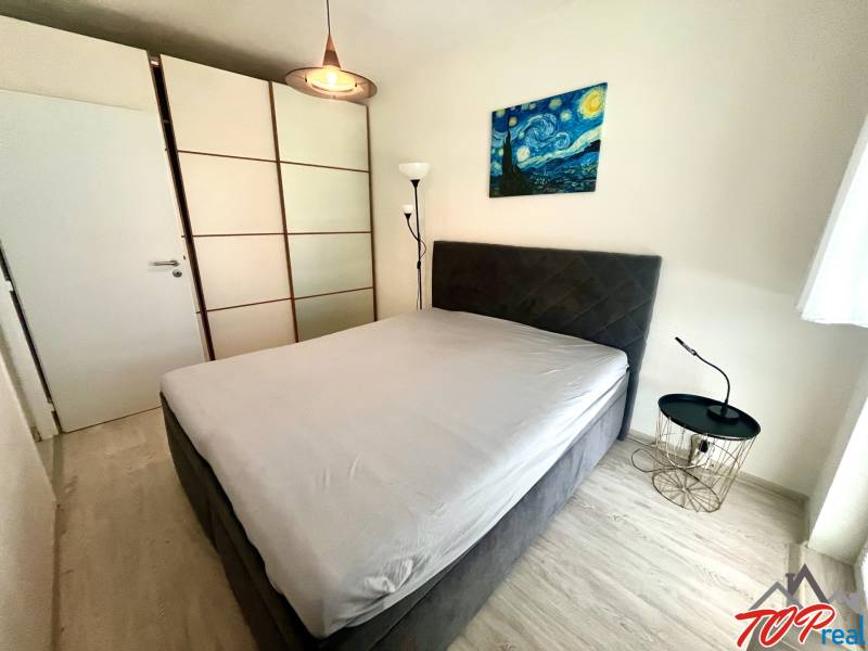 Hálószoba egy háromszobás lakásban gardróbszekrénnyel és éjjeliszekrénnyel.