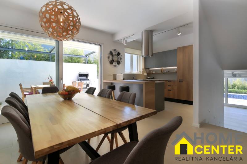 Villa belső tér nyitott konyhával, étkezőasztallal és teraszra nyíló hozzáféréssel.