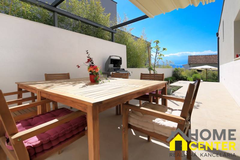 A balei villa terasza fa bútorokkal, grillel és virágokkal, kilátással a vidékre.