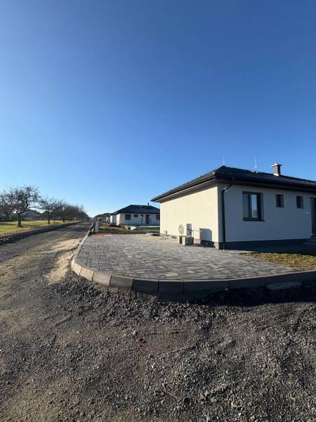 Családi ház a Vyšná Šebastová utcában, Eperjesen, kövezett terasz, tiszta kék égbolt.