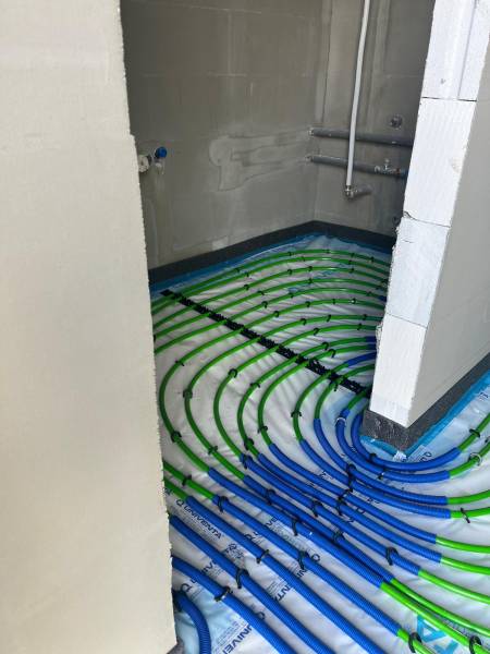 Padlófűtés egy családi házban a Vyšná Šebastová utcában, belső terekben történő vezetékek telepítése.