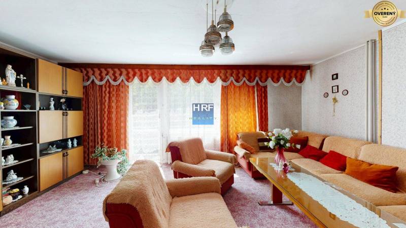 Nappali egy családi házban narancssárga függönyökkel és stílusos berendezéssel.