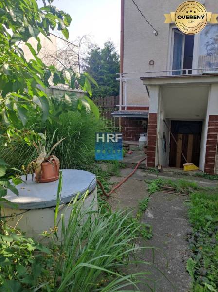 A Radošovce-i Vieska családi házának kertje pavilonnal és buja növényzettel.