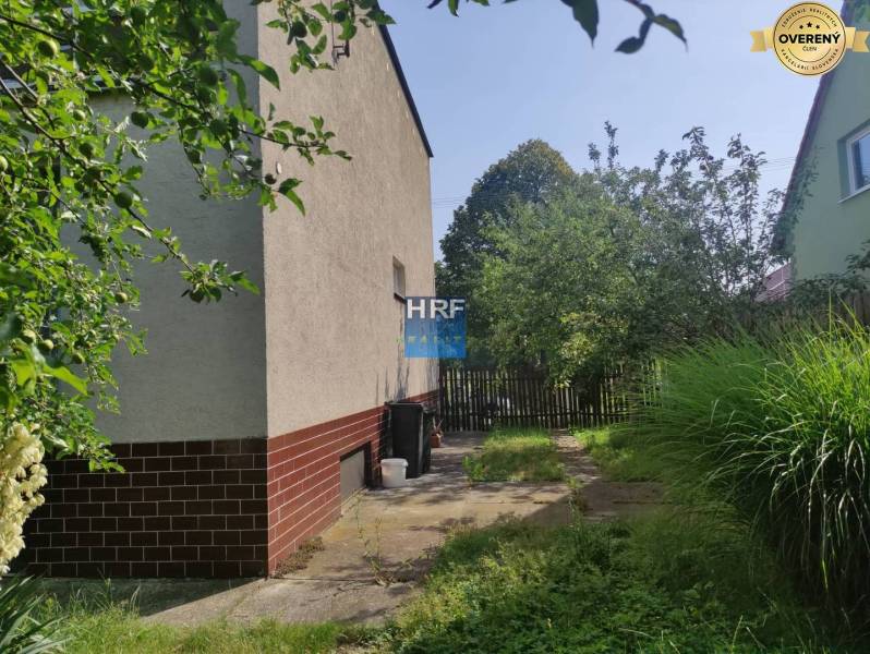 Kert a családi ház mellett Vieskán, Radošovcén, járdával és kerítéssel.