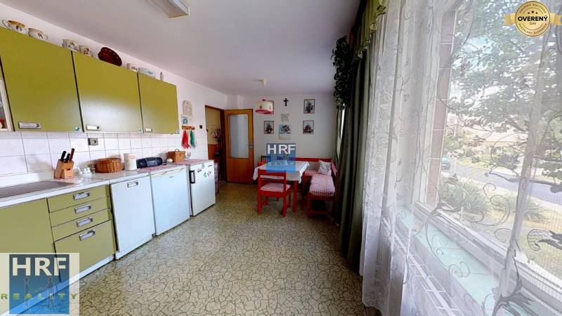 Családi ház konyhája retro bútorokkal, asztallal, nagy ablakkal és dekorációkkal.