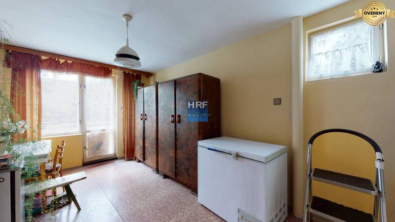 Rodinnaház belső tere fagyasztóval, szekrényekkel és nagy ablakkal.