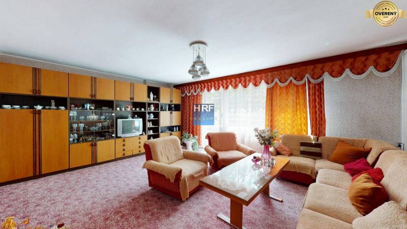 Nappali a családi házban kanapéval, nappali szekrénnyel és virágokkal.