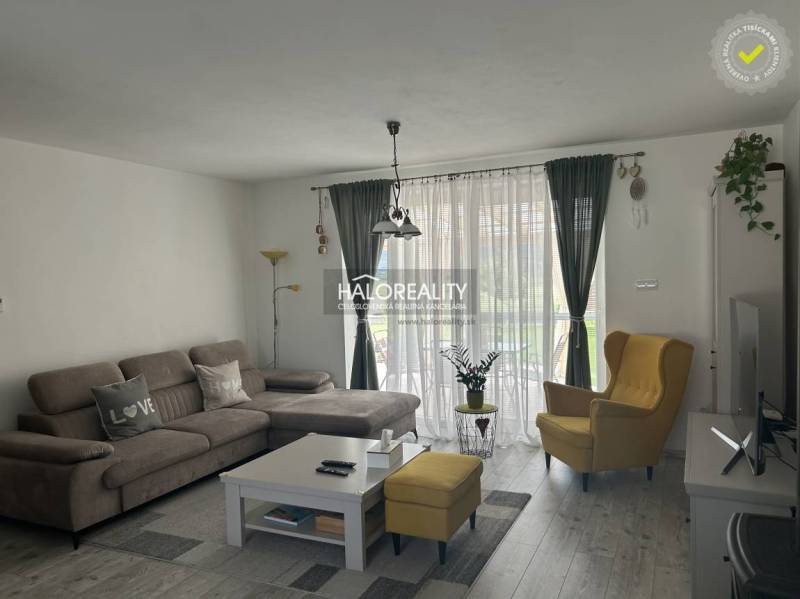 Nappali egy családi házban kényelmes kanapéval és sárga fotellel.