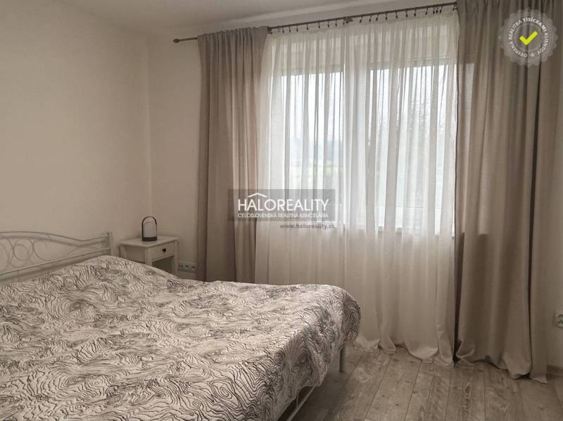 Hálószoba ággyal és függönyökkel családi házban, világos légkör.