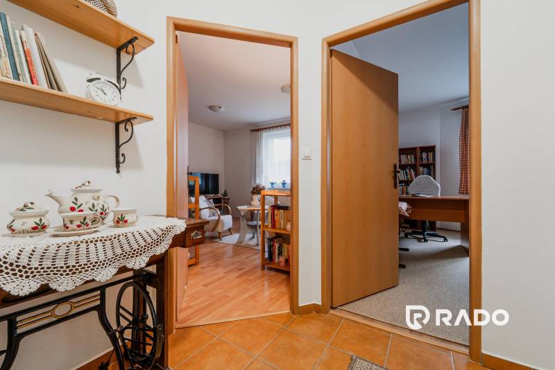 3 szobás lakás belső tere dekoratív kerámiával, könyvespolccal és szobákba vezető bejárattal.