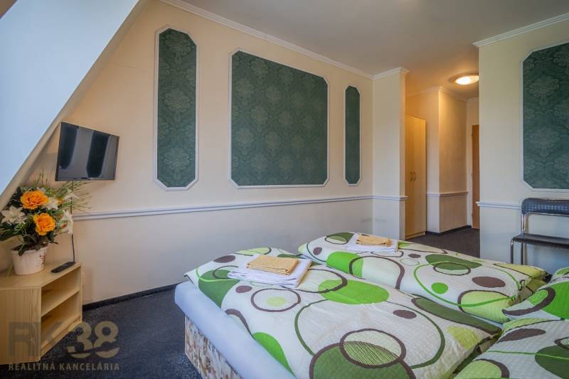 Szoba szállodákban és panziókban két ággyal, televízióval és virágokkal az asztalon.