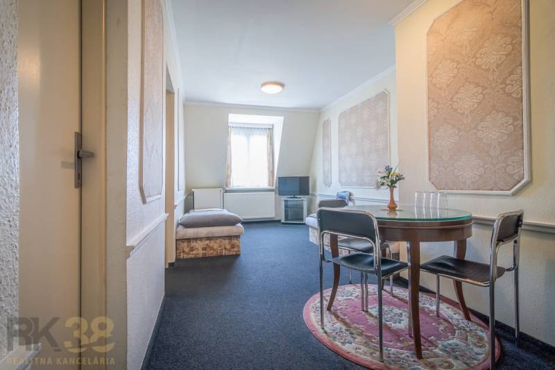 Szoba szállodákban és panziókban kerek asztallal és állványra helyezett televízióval.