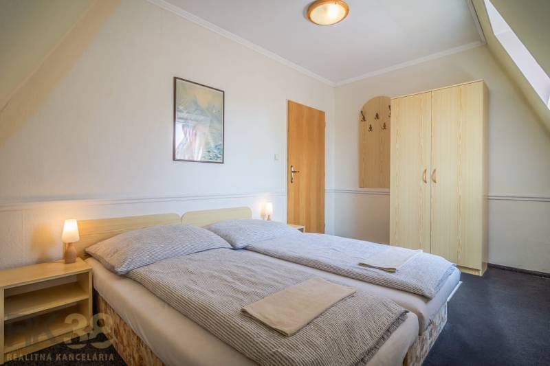 Kétszemélyes szoba ággyal, éjjeliszekrényekkel és szekrénnyel a szállodákban és panziókban.