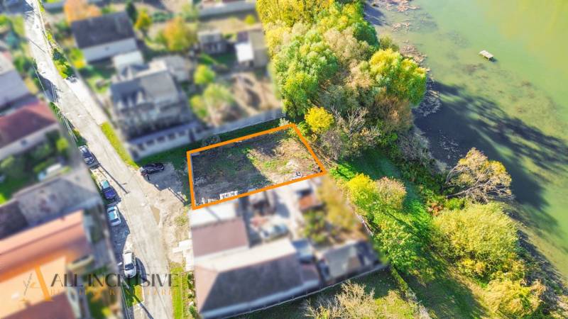 Telkek - lakóövezet a Jahodnában a folyó mellett, fákkal és gazdag növényzettel szegélyezve.