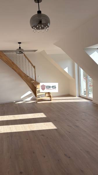 Tetőtéri helyiség egy háromszobás lakásban fa dekorációjú padlóval és lépcsővel.