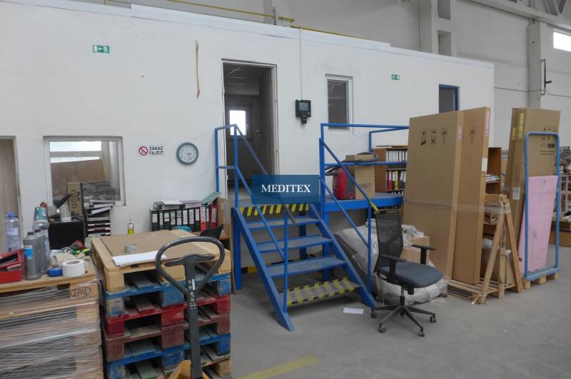 Raktárak és csarnokok lépcsővel, raklapokkal és irodai bútorokkal.