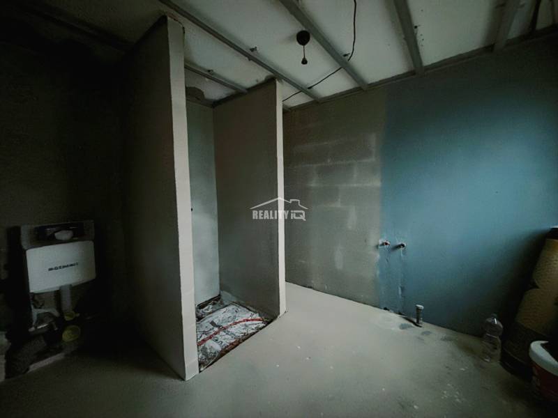 Családi ház belső tere befejezetlen fürdőszobával és WC, valamint mosdó előkészítéssel.