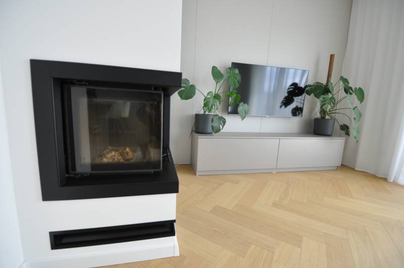 Nappali családi házban kandallóval, televízióval és fa dekorációjú padlóval.