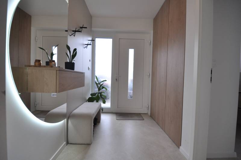 Családi ház előszobája nagy tükörrel és tárolóhelyekkel.