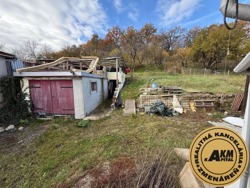 Családi ház Ókörmöcbányán elhanyagolt kerttel, régi garázzsal és fa szerkezettel.