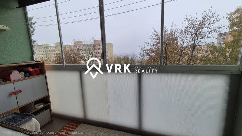 Üvegezett erkély egy háromszobás lakásban, kilátással panelházakra és fákra.