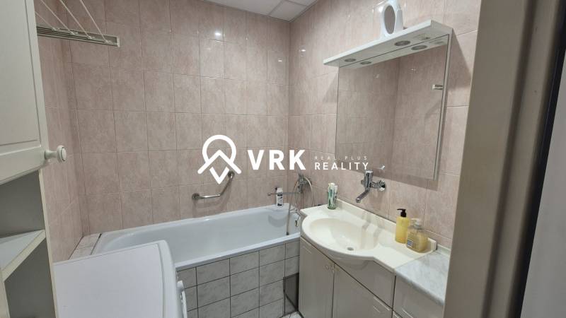 Fürdőszoba káddal, mosdóval és tükörrel egy háromszobás lakásban.