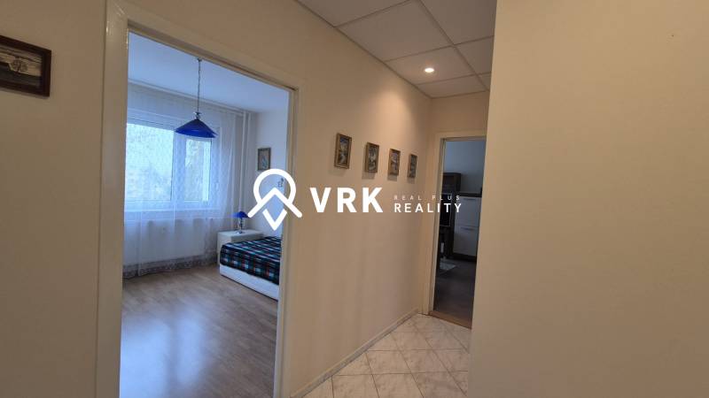 A háromszobás lakás hálószobájába vezető folyosó fa dekor padlóval.