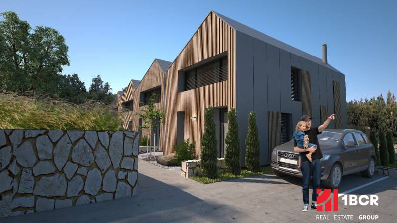 Családi házak Törökországban fa dekorációval, kőkerítéssel és parkoló autóval.