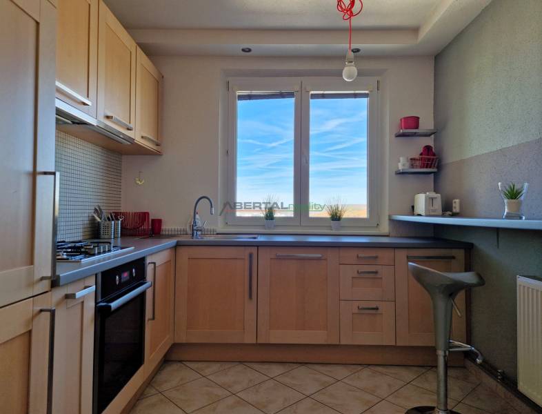 Konyha ablakkal, fa dekorációs padló, csempe, berendezés egy háromszobás lakásban.