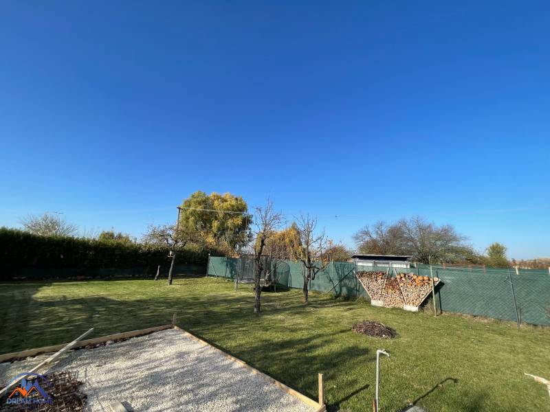 Kert a kunyhó mellett az Új telepen Komáromban, gyep és tűzrakóhely.