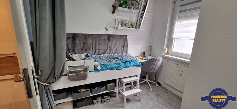 Gyerekszoba egy háromszobás lakásban, ággyal, tárolóhellyel és tanulósarokkal.