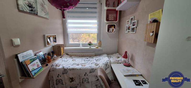 Gyerekszoba egy háromszobás lakásban dekorációkkal és íróasztallal.