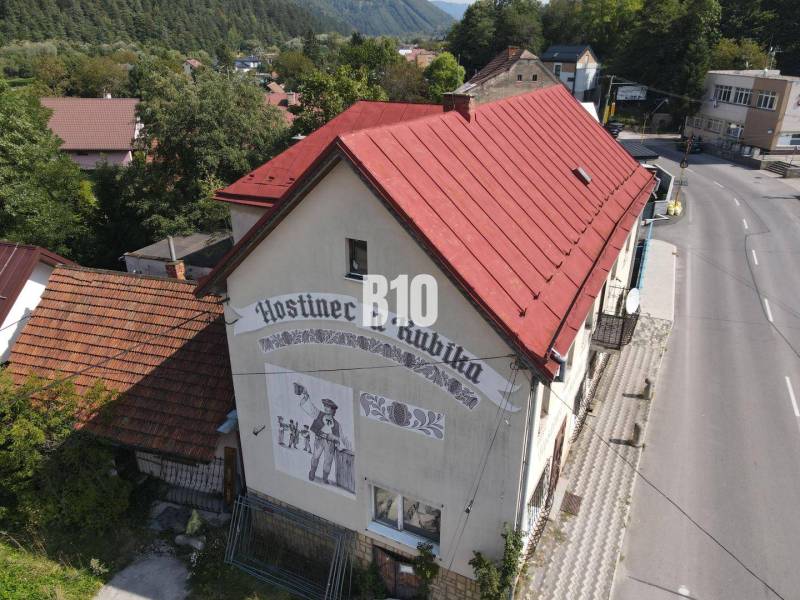 Fogadó épülete Bélán piros tetővel és falfestménnyel.