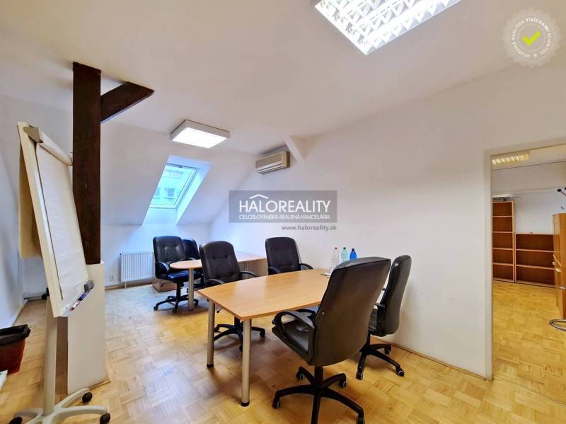 Irodák fa mintázatú padlóval és bútorokkal egy otthonos térben.