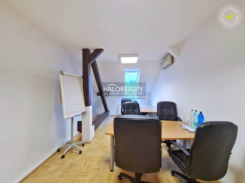 Irodák fa dekor padlóval, asztal, székek, flipchart, víz az asztalon.