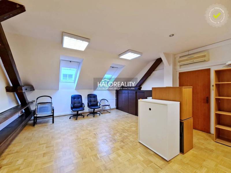 Irodák fa dekor padlóval, székekkel és ablakokkal a tetőtéri helyiségben.