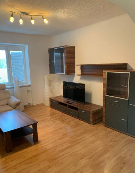 Nappali egy kétszobás lakásban fa dekorációjú padlóval és kényelmes kanapéval.