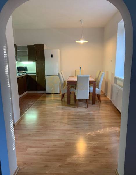 Étkező sarok egy kétszobás lakásban, fa dekoros padlóval és négy székkel.