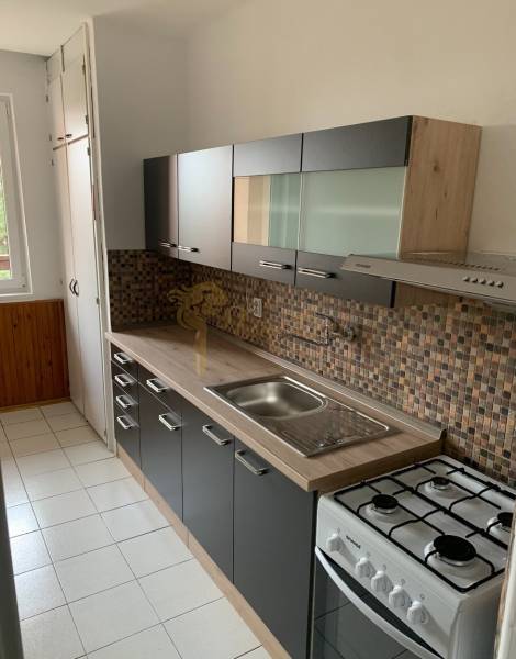 Konyha egy kétszobás lakásban mozaik csempével és gáz tűzhellyel.