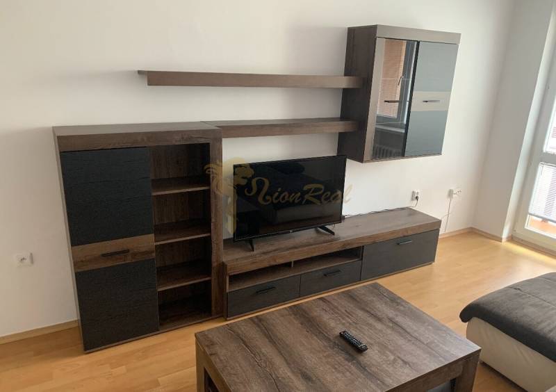 Nappali fal és televízió egy kétszobás lakásban, fa dekoros padlóval.