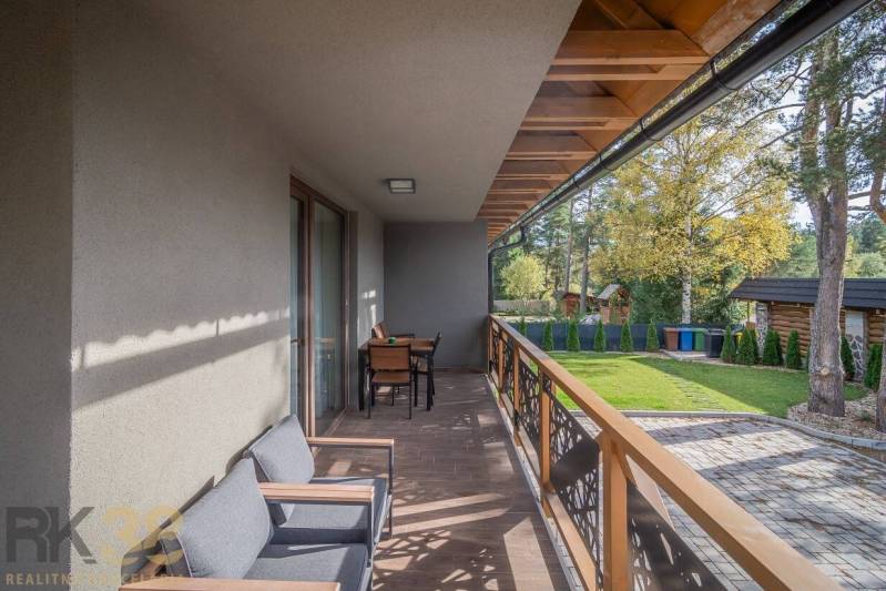 Erkély egy kétszobás lakásban Tátralomnicon, fa dekorációjú padlóval és kerti bútorokkal.