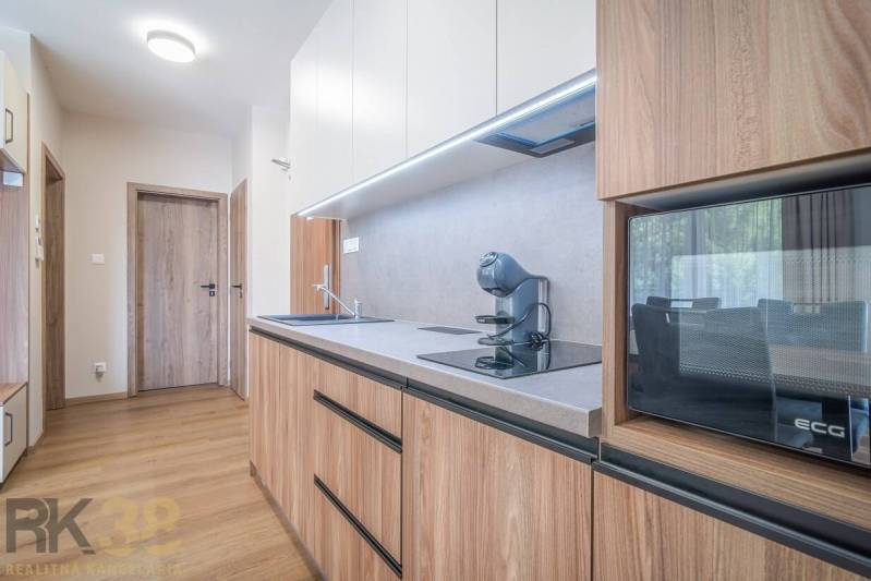 Konyha egy kétszobás lakásban, fa dekorációjú padlóval és modern felszereléssel.