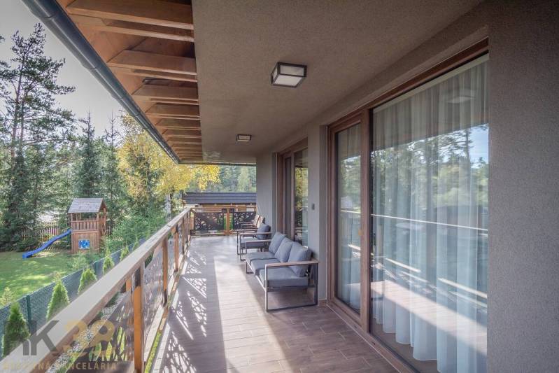 A Tátralomnici kétszobás lakás erkélye fa dekorációjú padlóval és kilátással a zöldre.