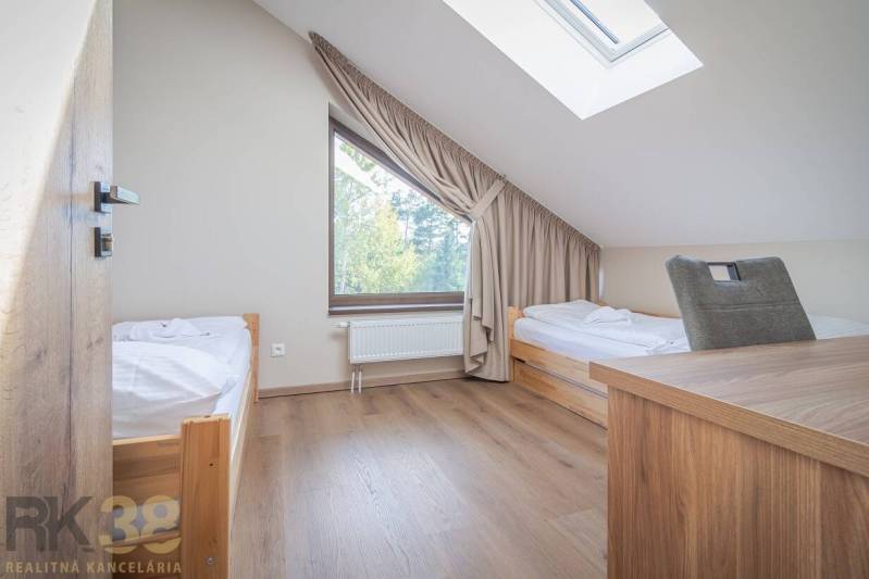 Hálószoba egy kétszobás lakásban két ággyal és fa dekorációjú padlóval.