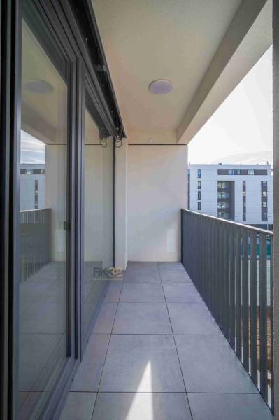 Erkély egy 2 szobás lakásban Poprádon, csempével és kilátással a modern épületekre.