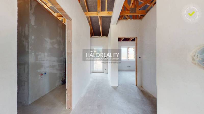 Családi ház belső tere, kilátással az átjáró folyosókra és a látható tetőszerkezetre.